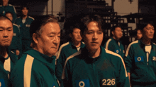 a group of men are standing together and one of them has the number 226 on his jacket