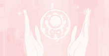 a pair of hands holding a pink circle with a bow on it .