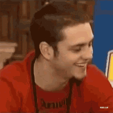 a man wearing a red shirt that says army smiles