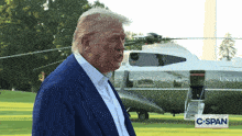 a man in a suit stands in front of a united states airplane