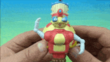 a person is holding a toy that looks like a cartoon character