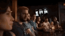 a group of people are sitting in a row watching a movie .