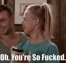 a woman in a ponytail is holding a can and says oh you 're so fucked .