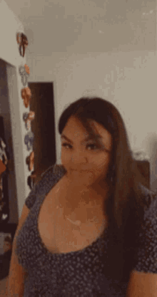 a woman is taking a selfie in a room with a wall of shoes hanging on it