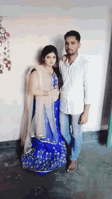 a man and a woman pose for a picture in a room