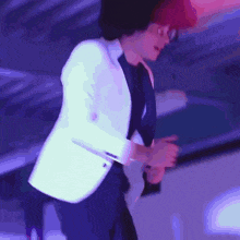 a man in a white jacket and black shirt is dancing