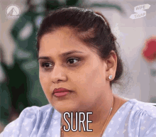 a woman with a serious look on her face and the word sure above her