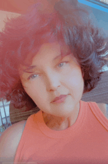 a woman with red hair is wearing a tank top