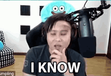 a man is sitting in front of a microphone with his eyes closed and a stuffed animal behind him .