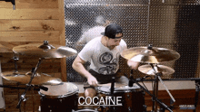 a man playing drums with the word cocaine on the bottom right