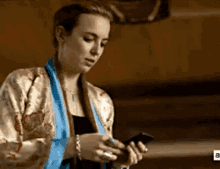 a woman is holding a cell phone in her hand .