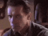 a close up of a man 's face in a room with a clock on the wall .