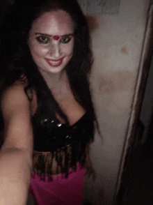 a woman is taking a selfie with her face painted and smiling .