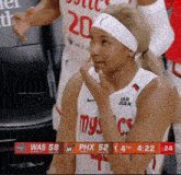 a female basketball player wearing a white jersey with phx on it