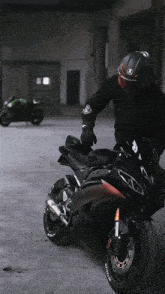 a man wearing a helmet and gloves is sitting on a black motorcycle with a michelin tire on it