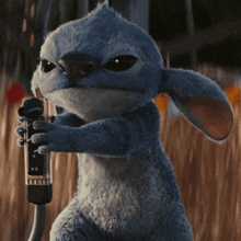 a blue stuffed animal is holding a hose in its paws