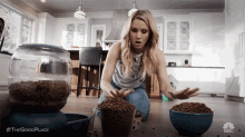 a woman is kneeling on the floor looking at bowls of dog food .