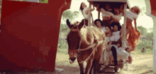 a group of women are riding on the back of a donkey drawn carriage