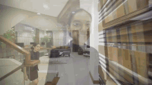 a woman is walking down stairs in a living room with a reflection of her face