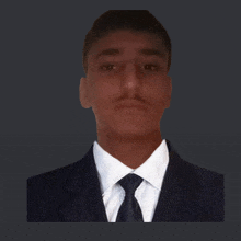 a man in a suit and tie looks at the camera with a dark background