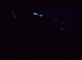 a man playing drums in a dark room with a microphone