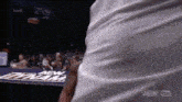 a man in a white shirt is standing in front of a sign that says aew on it