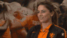 a woman wearing an orange and black shirt with a lion on it