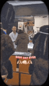 a group of people standing in front of a counter that says best day ever on it