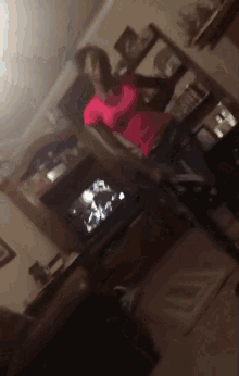 a woman in a red shirt is dancing in a living room