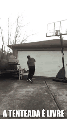 a man is jumping in front of a basketball hoop with the caption " a tenteada e livre " below him