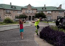 a boy and a girl are standing in front of a large building