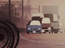 a blue alfa romeo is driving down the road