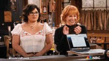 two women standing in front of a laptop with nbc written on the bottom left