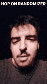 a man with a mustache is looking at the camera with the words hop on randomizer above him
