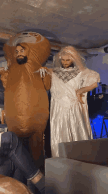 a man dressed as a sloth and a woman dressed as a bride are standing next to each other