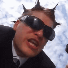 a man wearing sunglasses and a mohawk on his head