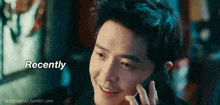a man is smiling while talking on a cell phone and the words recently are above him