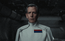 a man in a white uniform with a red and blue badge