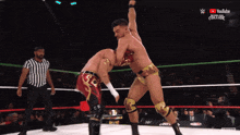 two men are wrestling in a ring with a youtube logo on the bottom