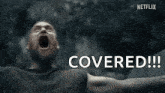 a man is screaming with his mouth open and the word covered is written above him .