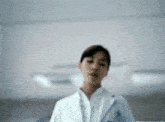 a blurry picture of a woman in a lab coat with the letter a on it