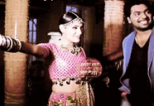 a woman in a pink top is dancing next to a man