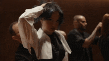 a woman with blue hair and a white shirt holds her hair up