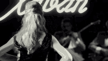 a woman is dancing in front of a sign that says " ivan "