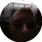 a close up of a man 's face in a circle with his eyes closed