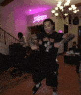 a man is dancing in front of a purple sign that says sharpie