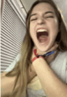 a woman is laughing and holding another woman 's neck in a blurry photo .