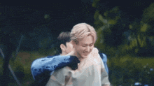a man is carrying another man on his back in the park .
