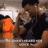 a man is sitting at a table wearing ear buds and crying while listening to music .
