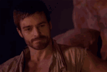 a man with a beard is smoking a cigarette in a cave .